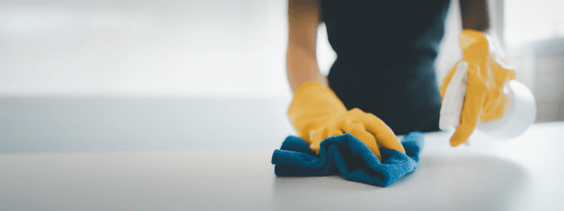 Cleaner polishing a surface with a blue cloth