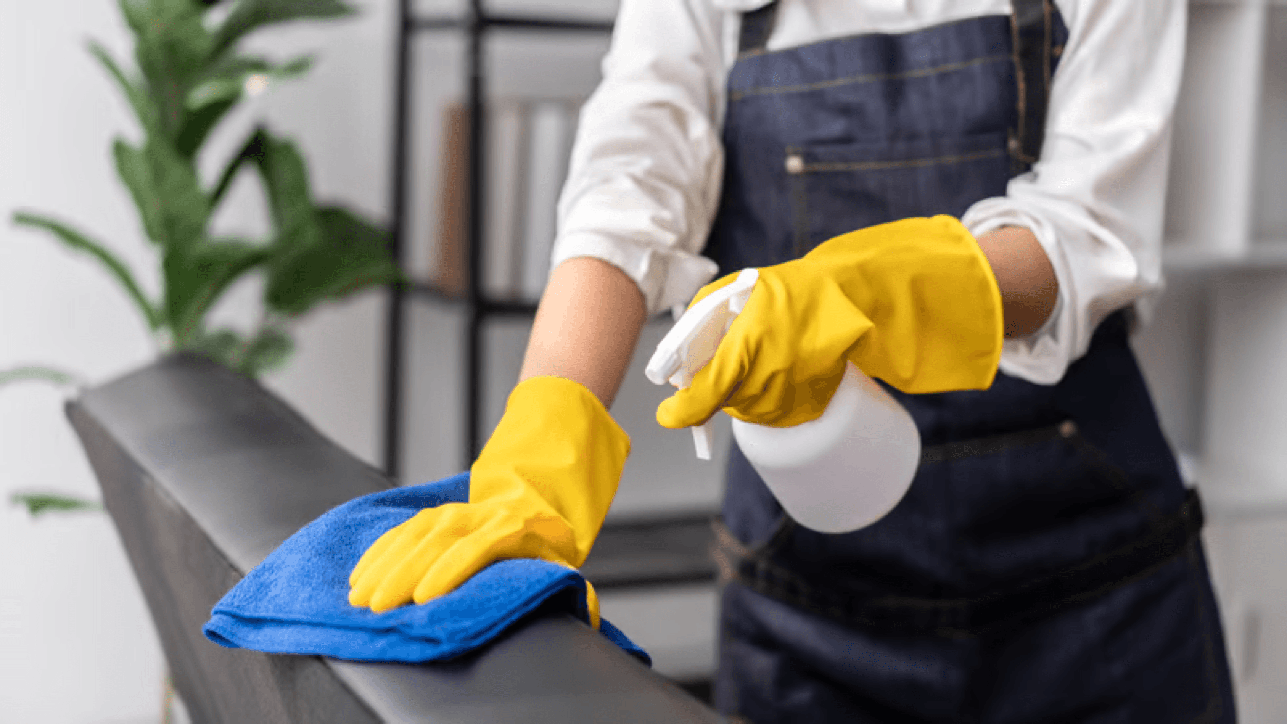 Cleaner in an apron wiping down a work surface